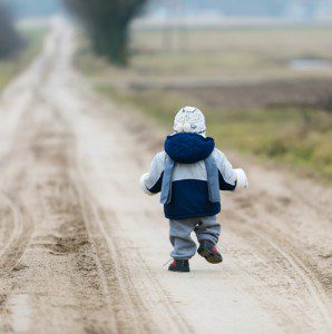 Toddler walking on a dirt road